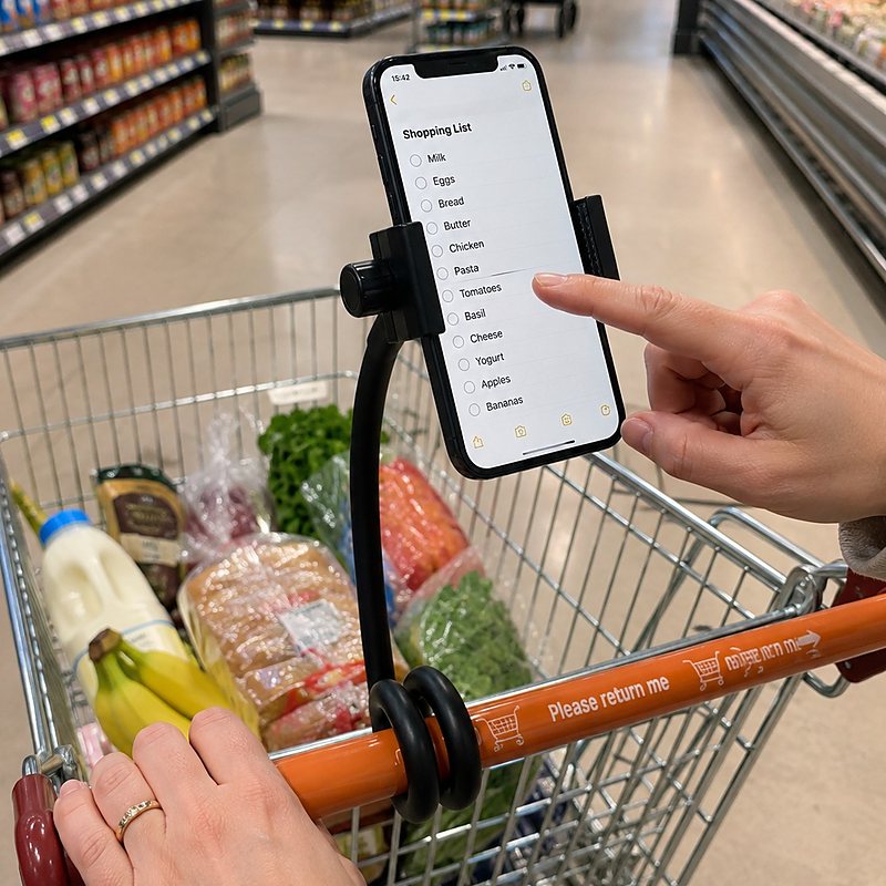 A phone showing a shopping list app, held at eye level by a Twistaroo phone holder on a supermarket trolley